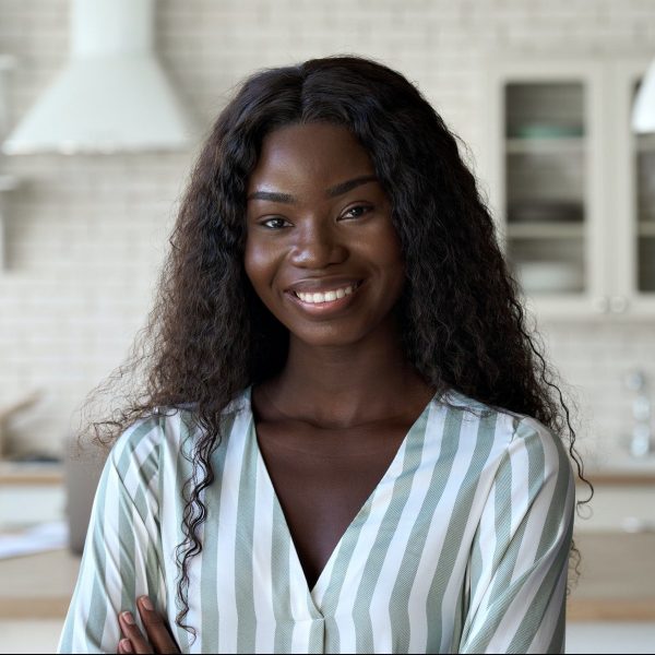 Headshot portrait of young black woman looking at camera indoors. Headshot portrait of young black woman looking at camera indoors.