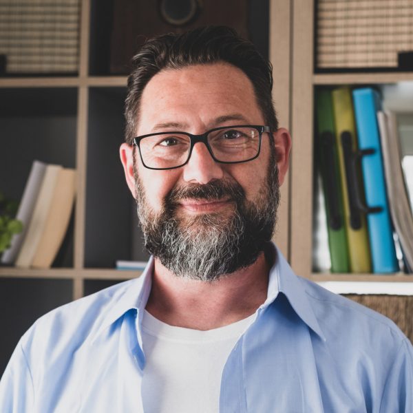 Portrait of one young and happy cheerful man smiling looking at Portrait of one young and happy cheerful man smiling looking at the camera having fun. Headshot of male person working at home in the office.